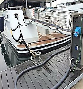 Manguera de extracción de aguas servidas conectada a una embarcación en el muelle