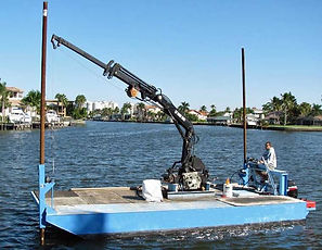 Bote de trabajo con grúa operando en un canal
