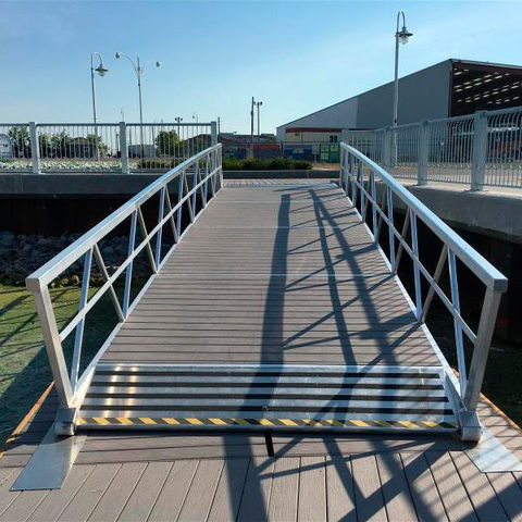 Pasarela de aluminio blanca con barandales sobre un canal