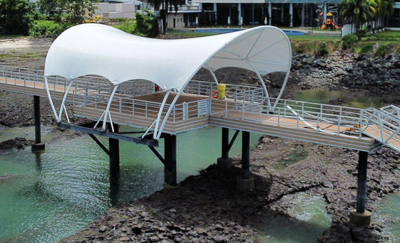 Velaria de diseño curvo instalada sobre un muelle con pasarela